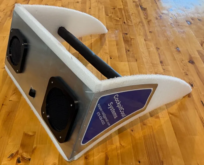 The CockpitCool plenum: an aluminum body with two black hose ports, white foam seals along every edge, and a padded crossbar.