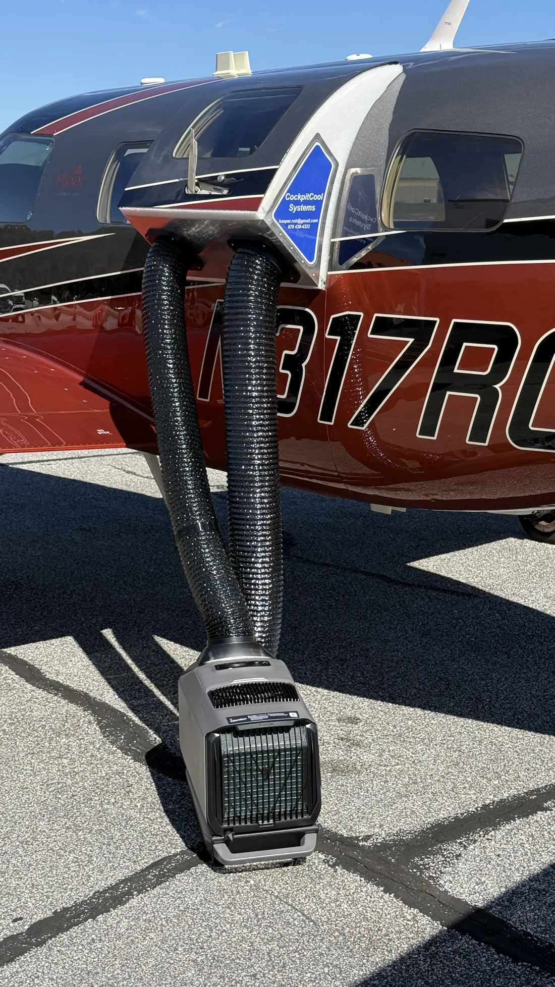 A PA-46 on the ramp with the CockpitCool plenum fitted in the upper door and two insulated hoses running down to an EcoFlow Wave 3 on the pavement.