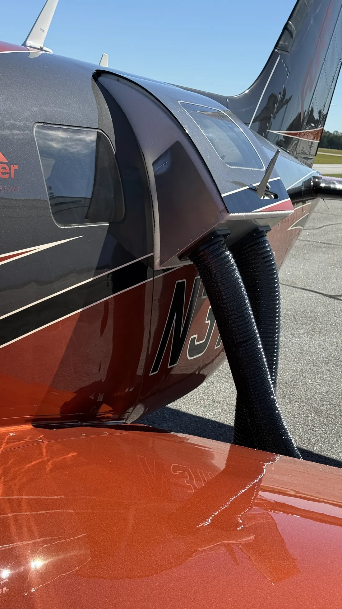 Rear-quarter view of the plenum in the upper door with both hoses running down the fuselage.